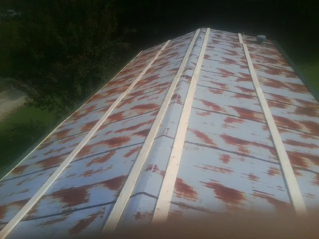 Rusted metal roof panels with new wood purlins before replacement — Storm Damage Roof Repair in Kearney by Roofing Brothers