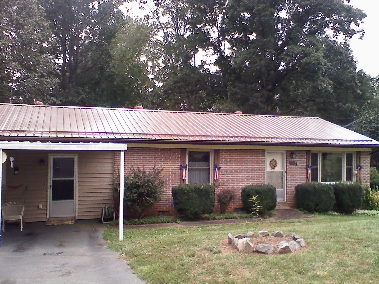 Bronze metal roof and carport on a brick ranch home — Roof Repair work by our crew in Kearney